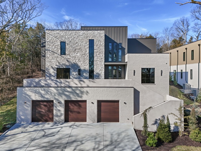 By renowned build and design team, Millworks, this home will take you out of Nashville and into an experiential environment amongst the treetops. The warm interior with oversized windows and colossal ceilings creates harmony with the surrounding natural beauty. The dining room features double doors that open up to the front porch. The backyard is unlike any other you've seen in Nashville, sloping upward to a large open space waiting for your unique touch...pool, pickleball court, party pavilion? The covered back porch with heaters and gas line for future grill, is just off of the open concept kitchen and living room for relaxed indoor/outdoor living. The main level primary suite features heated bathroom floors, dual entry shower and a massive closet. 4 upstairs bedroom suites surround the secondary living space. The basement level includes storage and an oversized suite for a home gym, golf sim or media room.