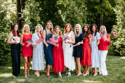 Women holding American flags in grass