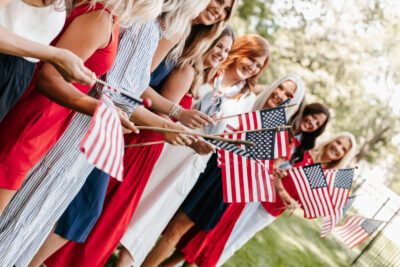Women holding american flags outside